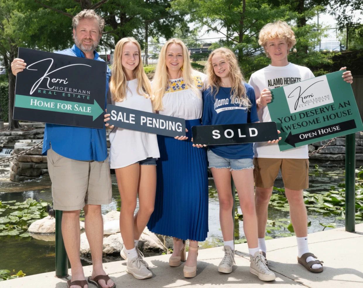 Kerri Hoermann and her family holding Sale Pending Sold and For Sale signs Kerri Real Estate